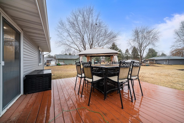 wooden terrace featuring outdoor dining area and a gazebo