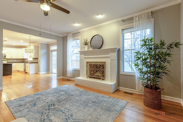 living room featuring light wood-style flooring, plenty of natural light, and ceiling fan
