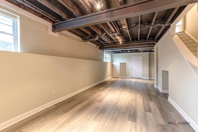 basement featuring baseboards and wood finished floors