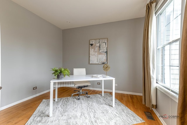 office with visible vents, baseboards, and wood finished floors