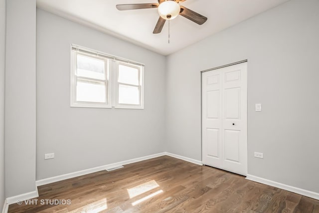 unfurnished bedroom featuring visible vents, baseboards, and wood finished floors