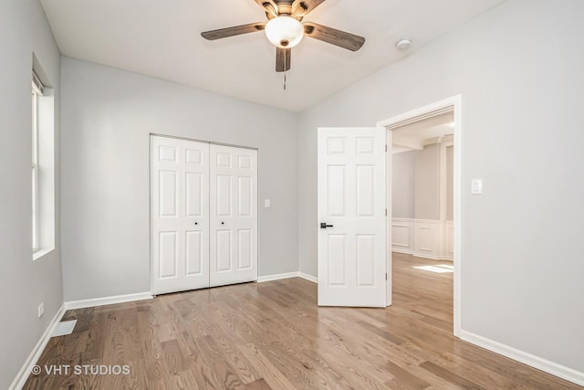 unfurnished bedroom with ceiling fan, light wood finished floors, a closet, and baseboards