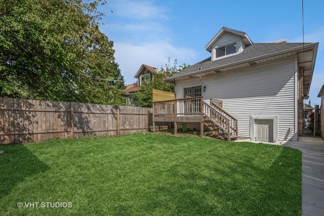 rear view of house featuring fence, a deck, and a yard