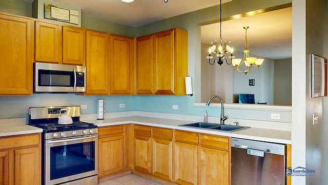 kitchen featuring a sink, an inviting chandelier, appliances with stainless steel finishes, light countertops, and hanging light fixtures