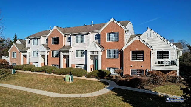 view of front of house featuring a residential view, brick siding, and a front lawn