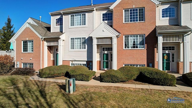 view of front of house with brick siding and a front lawn