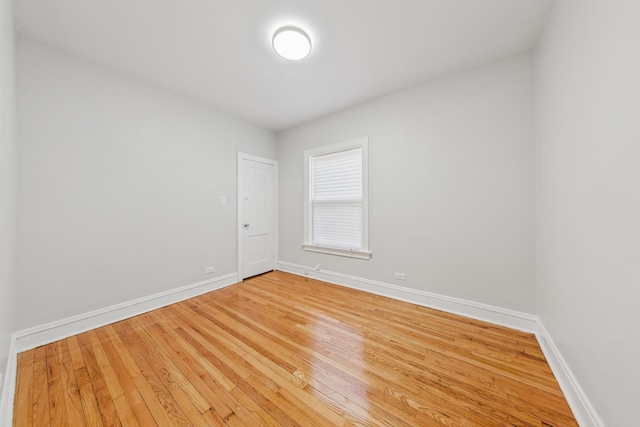 empty room featuring wood-type flooring and baseboards