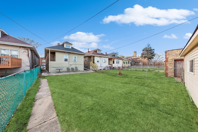 rear view of house with a lawn and a fenced backyard