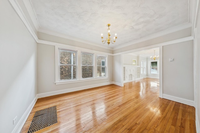 unfurnished living room with plenty of natural light, light wood-style flooring, and an inviting chandelier