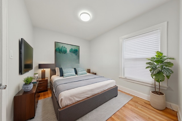 bedroom with baseboards and wood finished floors