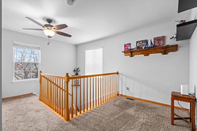 hallway featuring an upstairs landing, carpet, visible vents, and baseboards