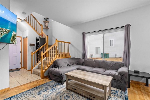 living room featuring stairway, wood finished floors, and baseboards