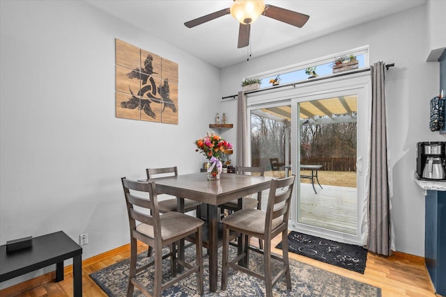 dining area with a ceiling fan, baseboards, and light wood finished floors