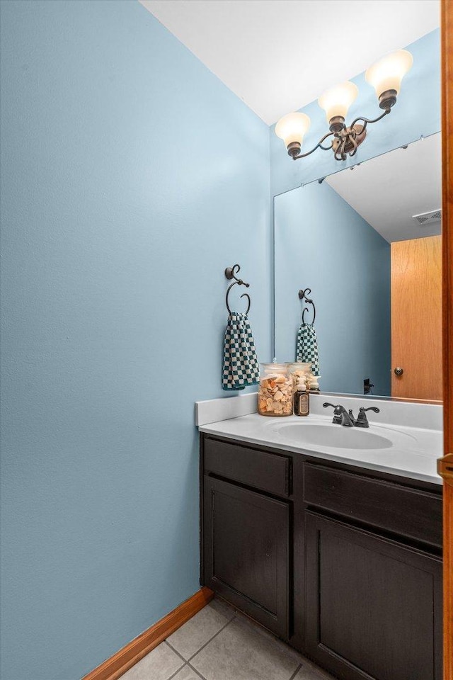 bathroom featuring tile patterned flooring, visible vents, vanity, baseboards, and an inviting chandelier