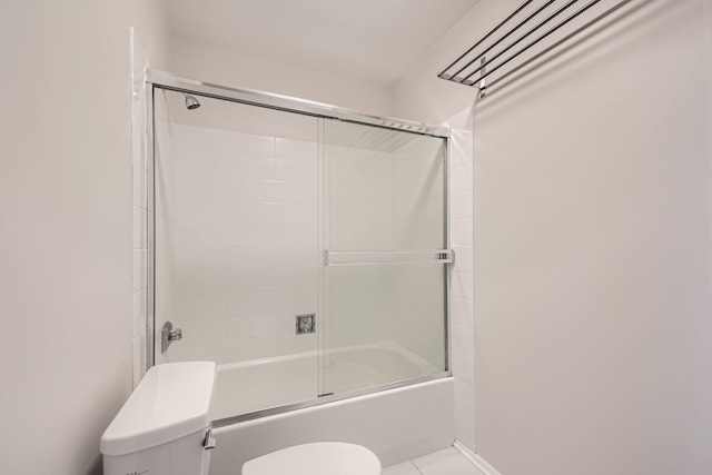 bathroom featuring shower / bath combination with glass door, toilet, and tile patterned floors