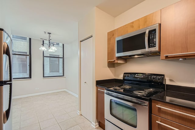 kitchen with decorative light fixtures, dark countertops, appliances with stainless steel finishes, a chandelier, and baseboards