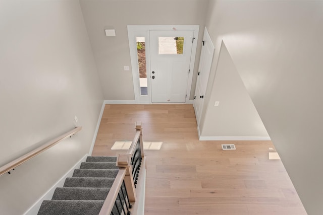 entryway featuring visible vents, stairs, baseboards, and wood finished floors