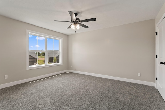 carpeted empty room with a ceiling fan and baseboards