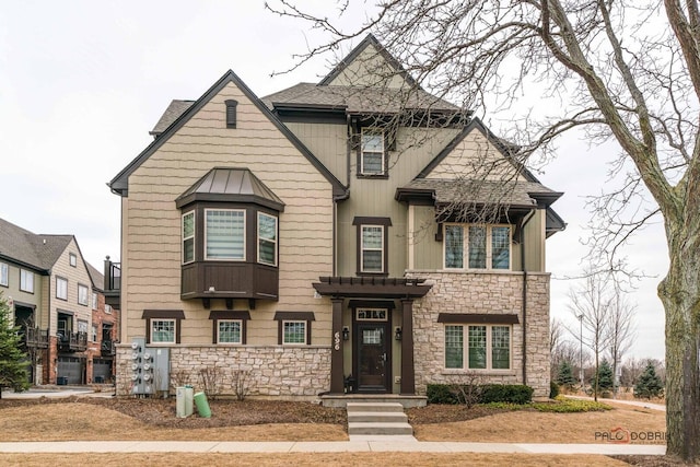 view of front facade featuring stone siding and roof with shingles