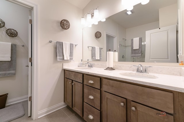 full bathroom with a sink, double vanity, a shower stall, and tile patterned flooring