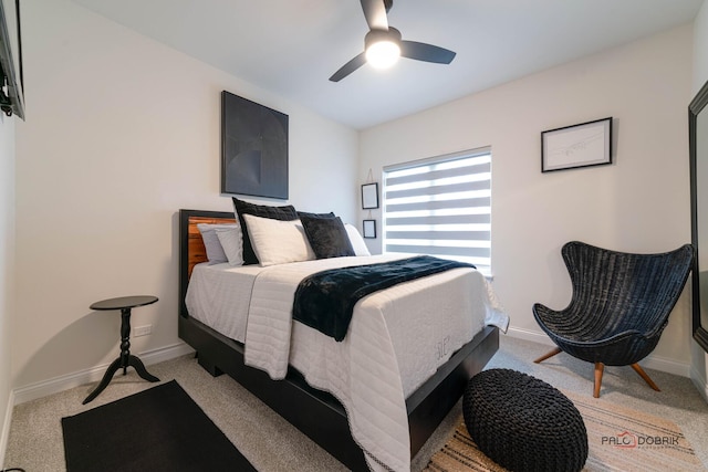 bedroom with light colored carpet, baseboards, and ceiling fan