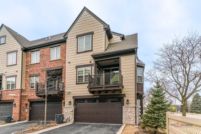 multi unit property featuring aphalt driveway, stone siding, and central AC