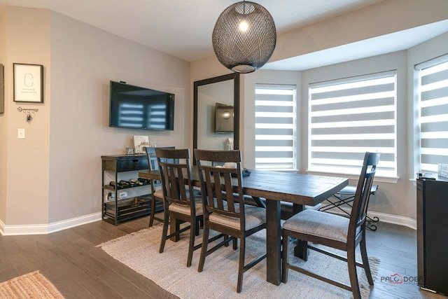 dining space featuring baseboards and wood finished floors