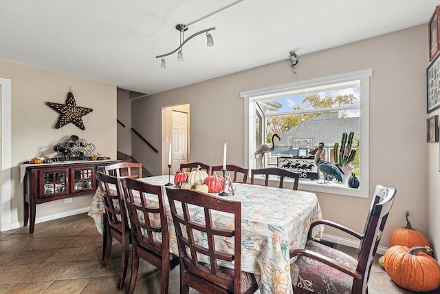 dining space with baseboards and stairs