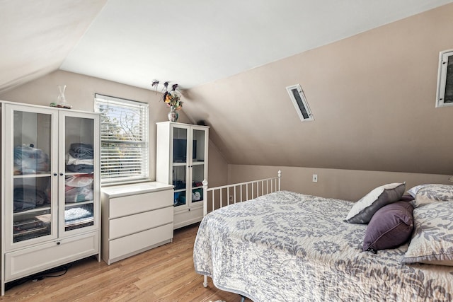 bedroom featuring light wood-style floors and vaulted ceiling