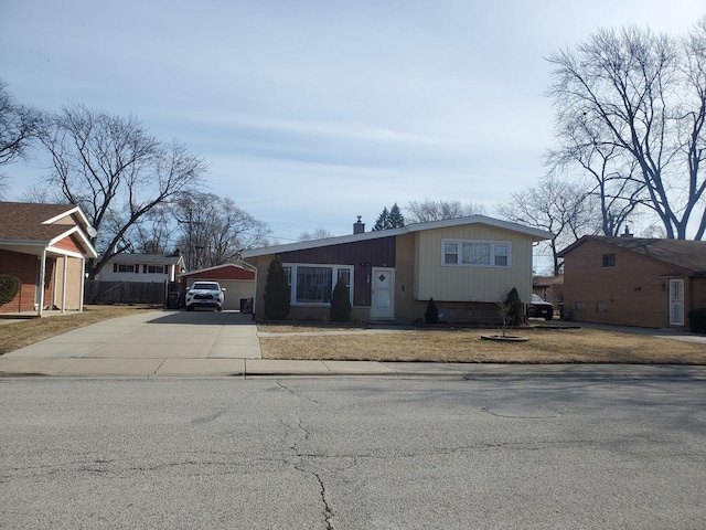 view of front of home with driveway and fence