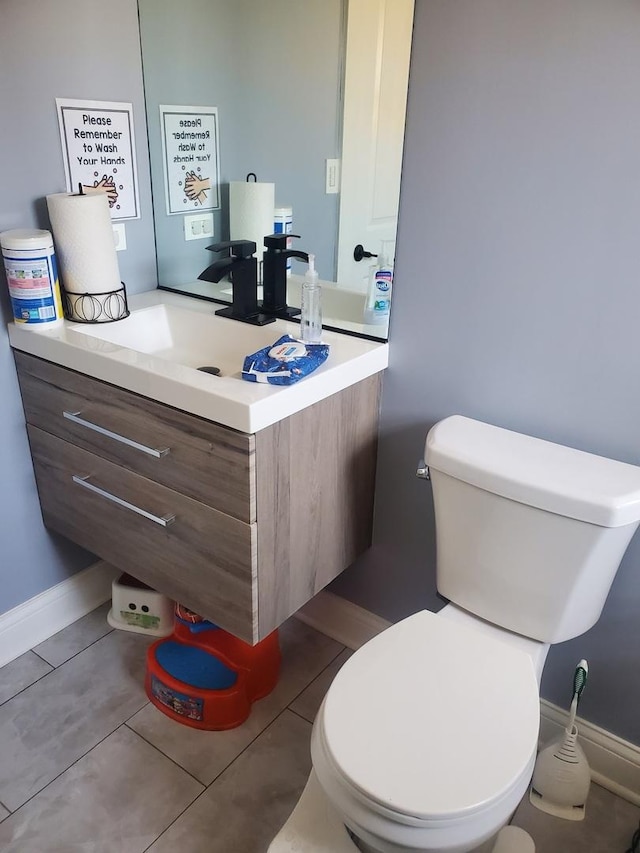 bathroom featuring vanity, tile patterned flooring, toilet, and baseboards