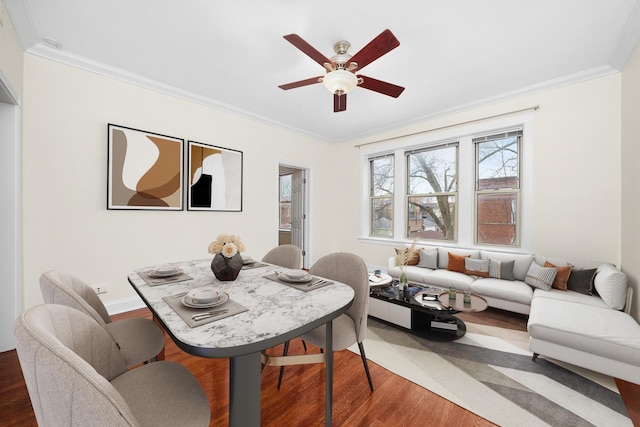 dining room featuring crown molding, ceiling fan, and wood finished floors