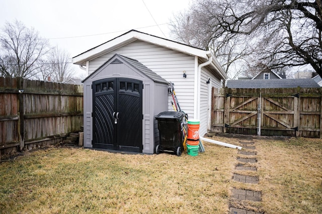 view of shed featuring a fenced backyard and a gate