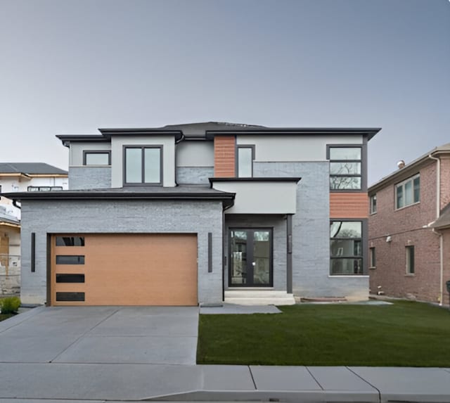 view of front of house featuring concrete driveway, an attached garage, and a front lawn