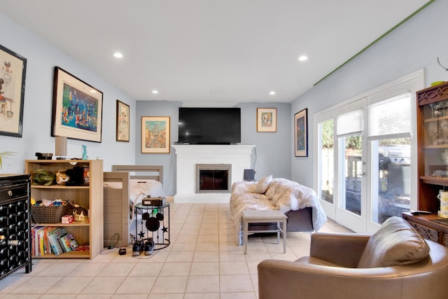 living area featuring recessed lighting, tile patterned flooring, and a glass covered fireplace