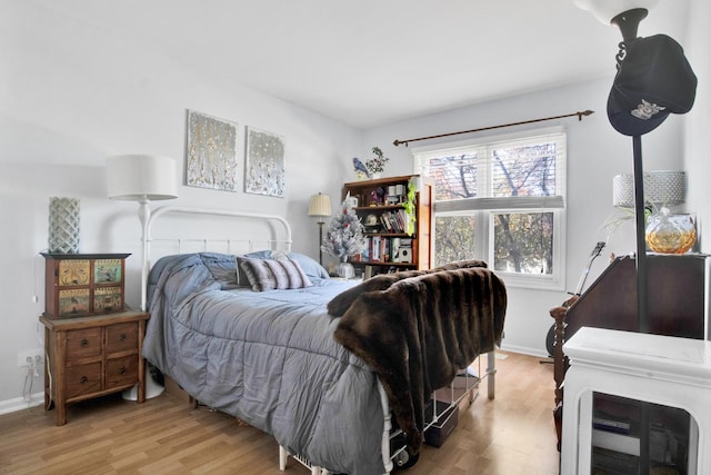 bedroom with light wood-type flooring and baseboards