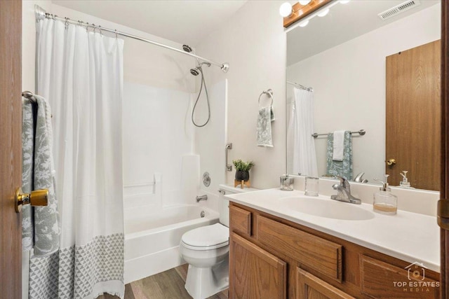 bathroom with visible vents, toilet, shower / tub combo, wood finished floors, and vanity