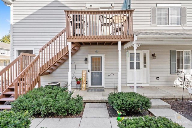 view of exterior entry with covered porch and central AC