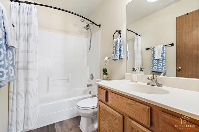 bathroom with vanity, toilet, wood finished floors, and shower / bath combo