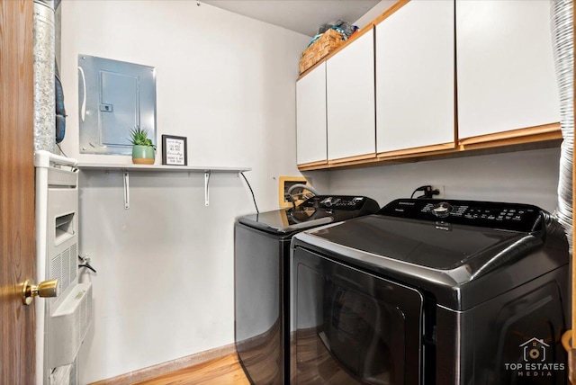 washroom with washer and dryer, electric panel, and cabinet space