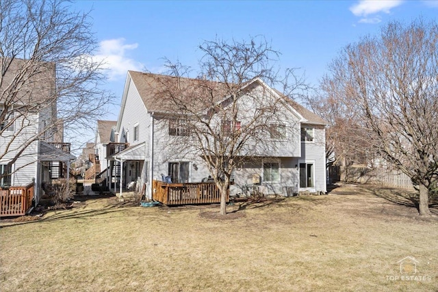 back of house featuring a lawn and a deck