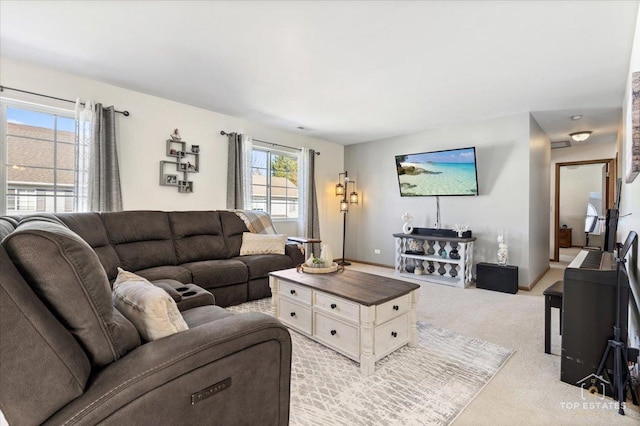 living area with baseboards and light colored carpet