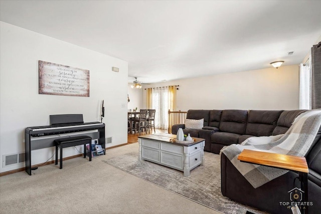 living room with visible vents, light colored carpet, a ceiling fan, and baseboards