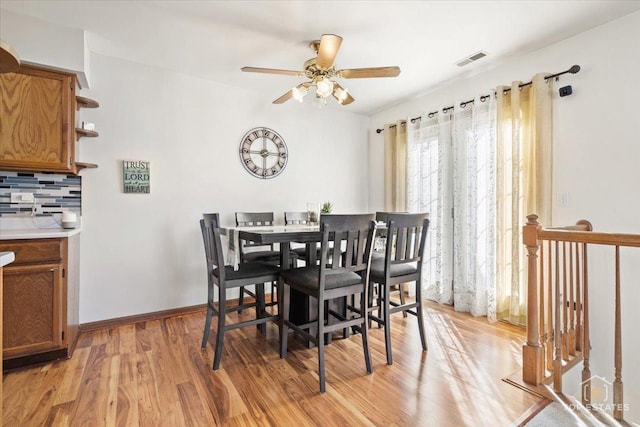 dining room featuring visible vents, baseboards, light wood-style floors, and a ceiling fan