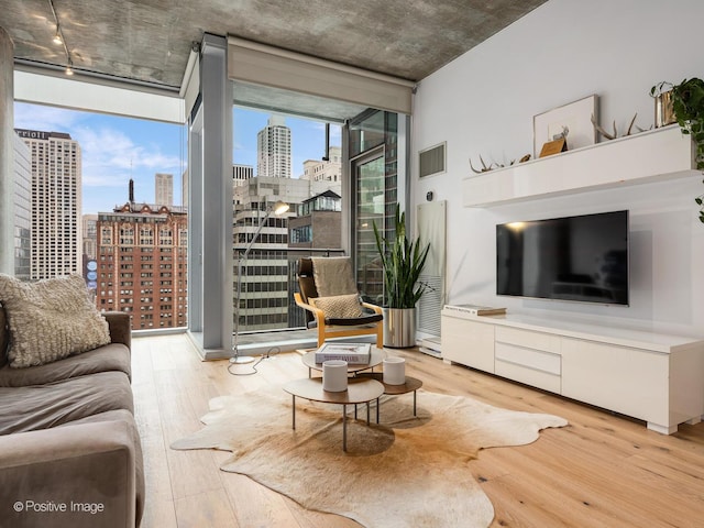 living room with visible vents, hardwood / wood-style floors, and floor to ceiling windows