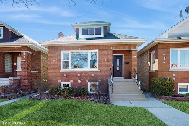 view of front of house featuring brick siding and a front yard