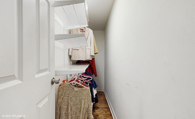 walk in closet with wood finished floors