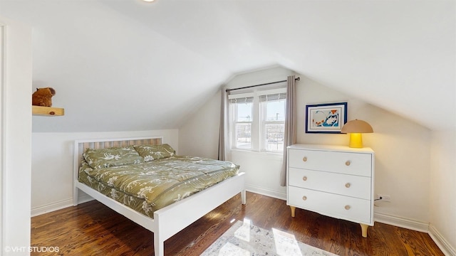 bedroom with vaulted ceiling, baseboards, and wood finished floors