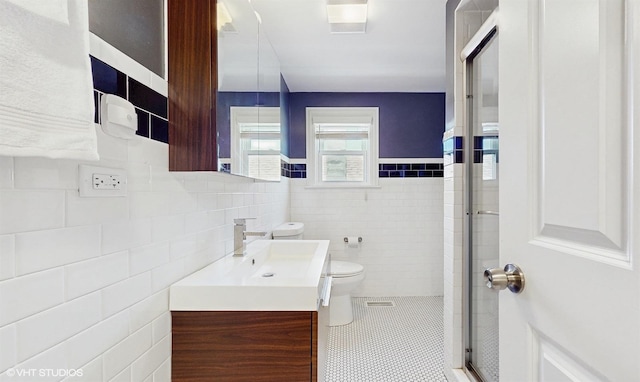 full bathroom with vanity, a stall shower, tile patterned floors, toilet, and tile walls