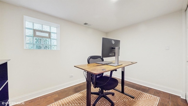 office space with visible vents, baseboards, and dark wood-style flooring